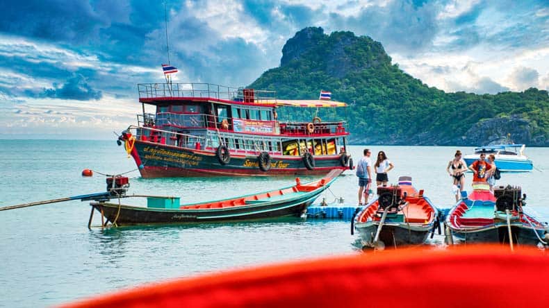Blick auf bunte Boote und eine grüne Insel im Hintergrund, Koh Samui, Thailand