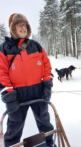 Mann mit Hundeschlitten im Schnee