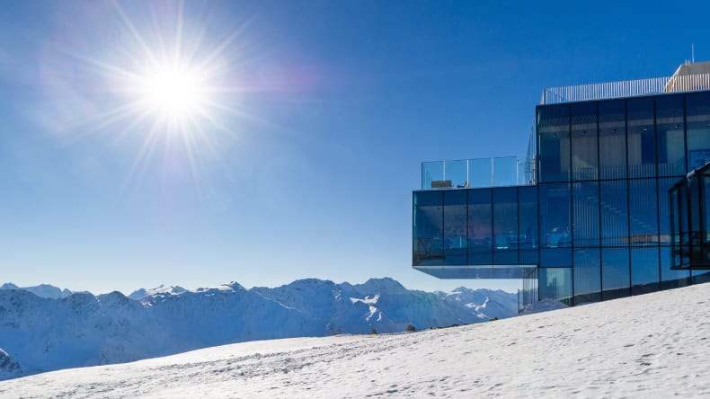 Blick auf ein gläsernes Gebäude auf einem schneebedeckten Berggipfel, Österreich