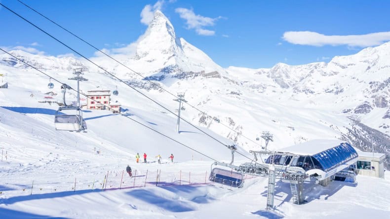 Blick auf den Matterhorn und Seilbahn mit Skifahrern, Zermatt, Schweiz