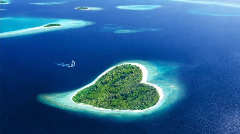 Blick auf eine herzförmige tropische Insel aus der Vogelperspektive, Malediven, Indischer Oean