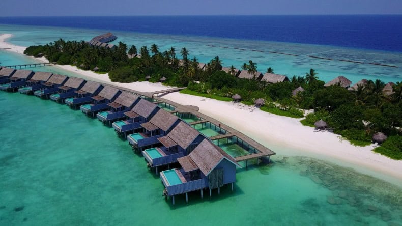 Blick auf die Insel Kuramathi Island Resort mit Pool Overwater Bungalows, den weißen Strand, türkisfarbenes Meer und eine Sandbank, Malediven, Indischer Ozean