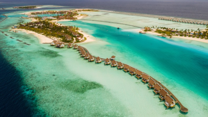 Blick auf eine Insel mit Overwater Bungalows und eine große türkisfarbene Lagune, SAii Lagoon Maldives, Malediven, Indischer Ozean