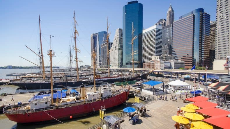 Im Seaport District in Lower Manhattan, ankern historische Segelschiffe am Pier 16 vor der beeindruckenden Skyline von New York.